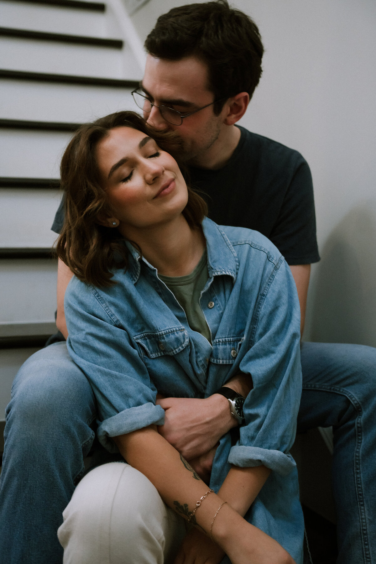 man hugging female partner, sitting on stairs