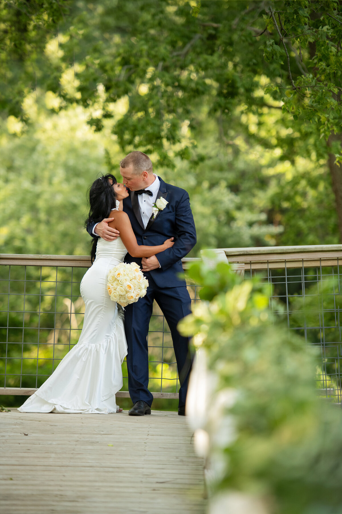 Groom and bride just got married and kissing each other outside in the woods