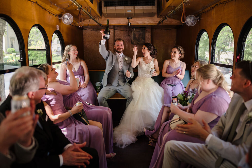 Bride and groom drink champagne on a Chicago Trolley