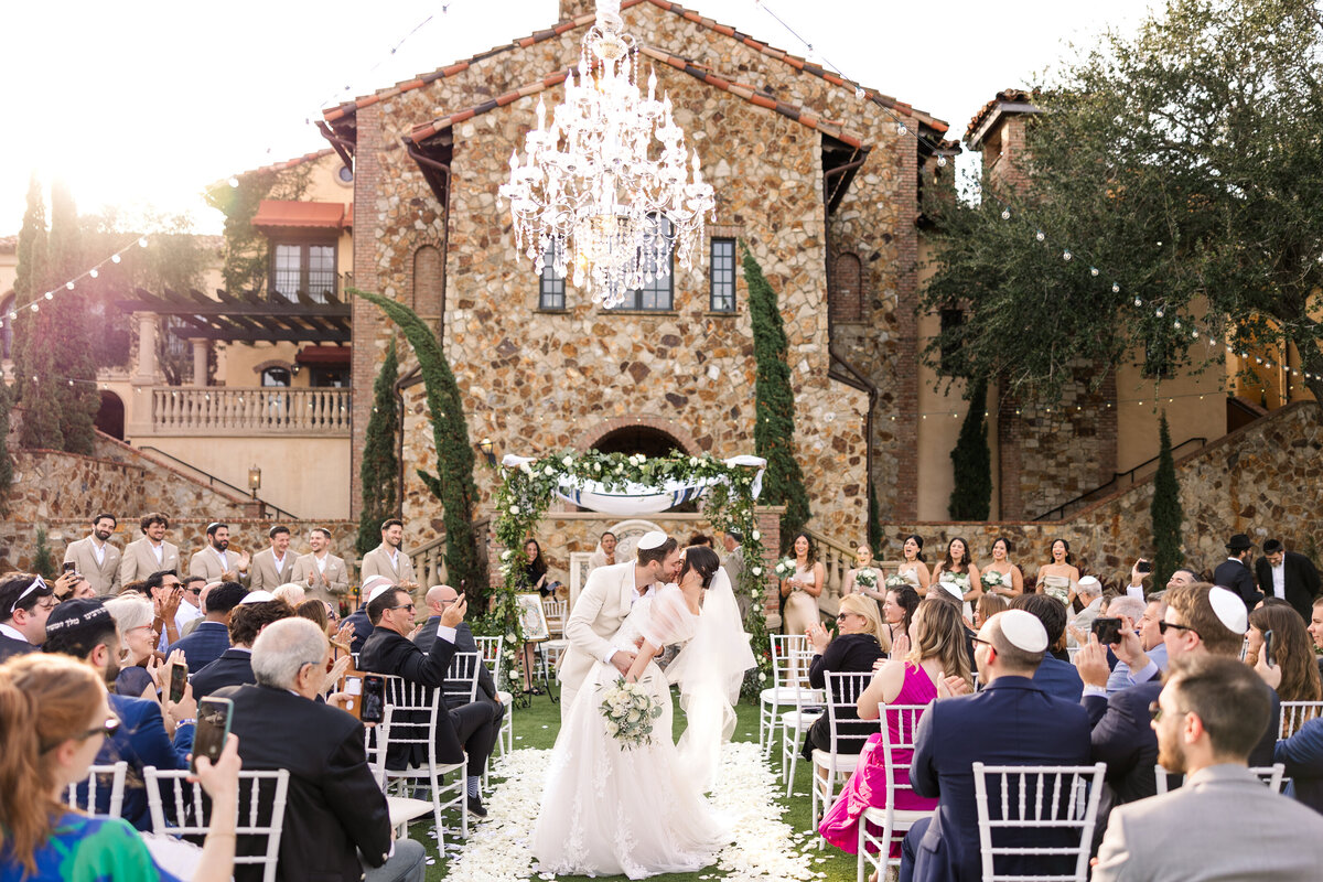 Bride and Groom kissing during wedding ceremony at Bella Collina Wedding