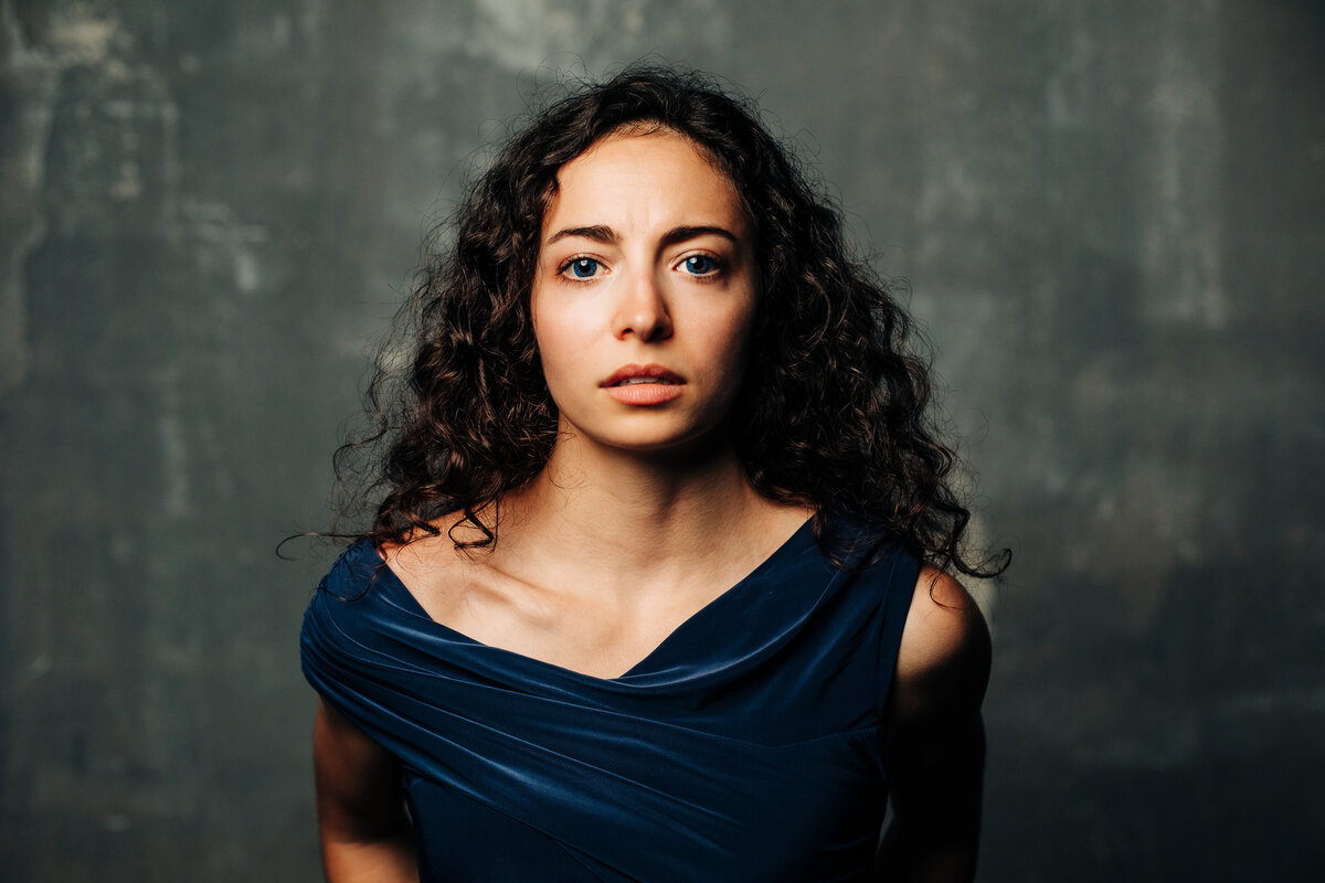 Closeup of woman with dark background, intense, passionate, for branding photoshoot