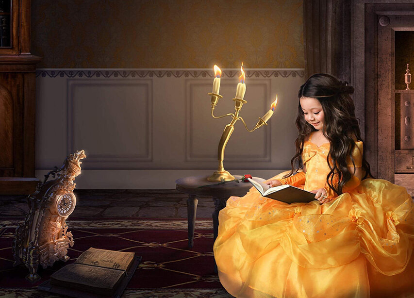 Girl posing in snow white dress reading a book with digital scene behind her.