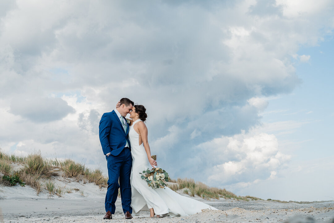 romantic-couple-kiss-beach-wedding-nj-cloudy-sky