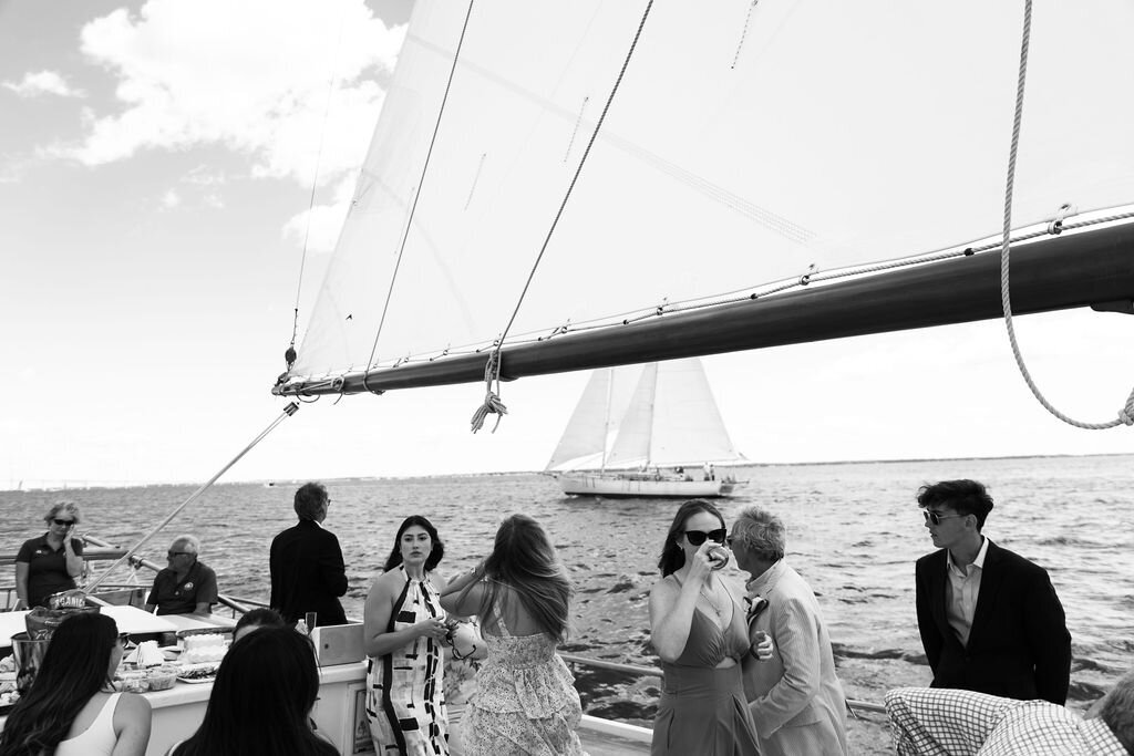 Bride and groom sailing on a classic white sailboat during their romantic elopement in Annapolis, Maryland, with the Chesapeake Bay in the background