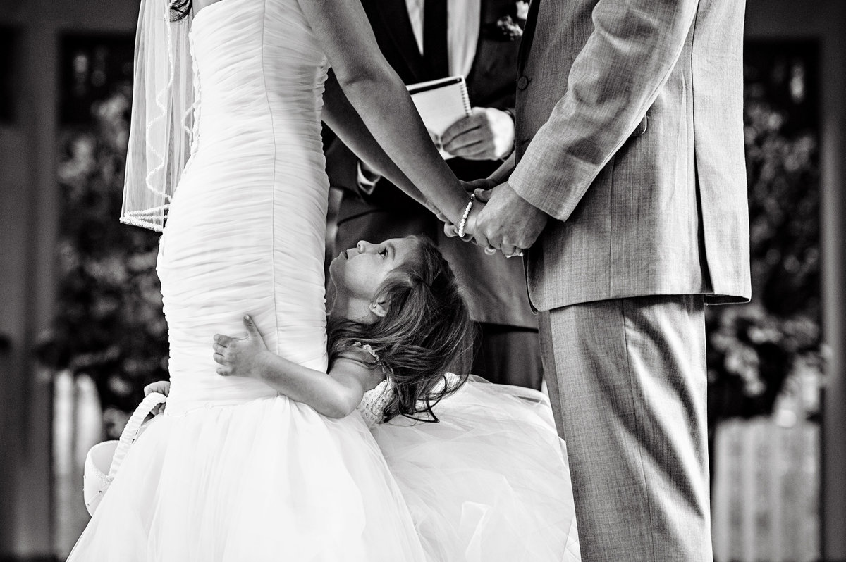 A little girl in between her parents as they get married at Scotland Run Golf Club in New Jersey.