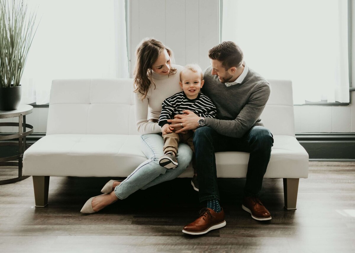 Capture beautiful moments of a Pittsburgh family on a white couch with their adorable baby.