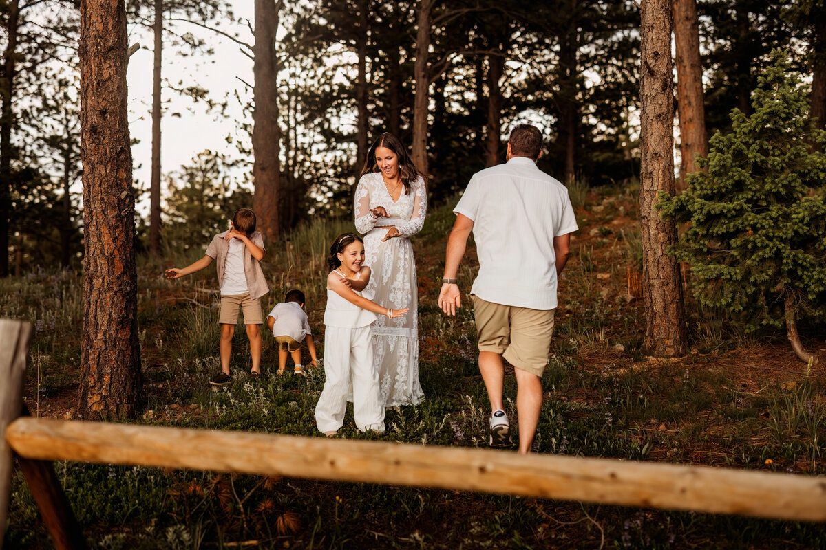 Family of five dance in the woods of Colorado forests for their fun and intimate family photo session