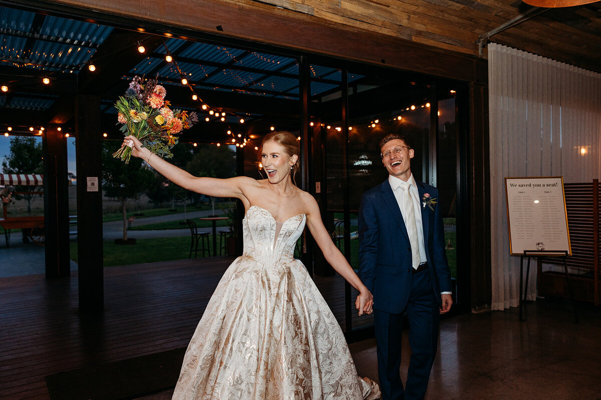 Bride and groom excited during their grand entrance to their wedding reception