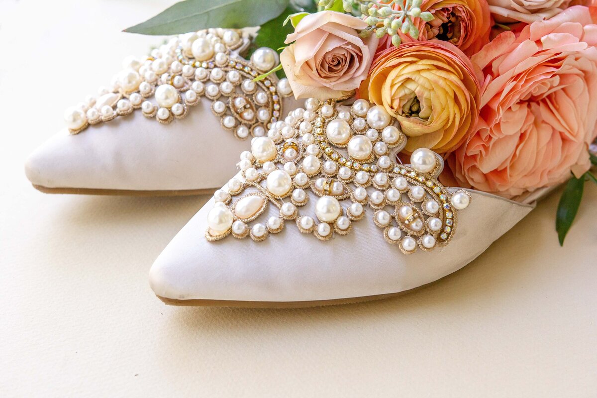 pearl lines shoes with peach ranunculas and pink peonies wedding detail by Firefly Photography