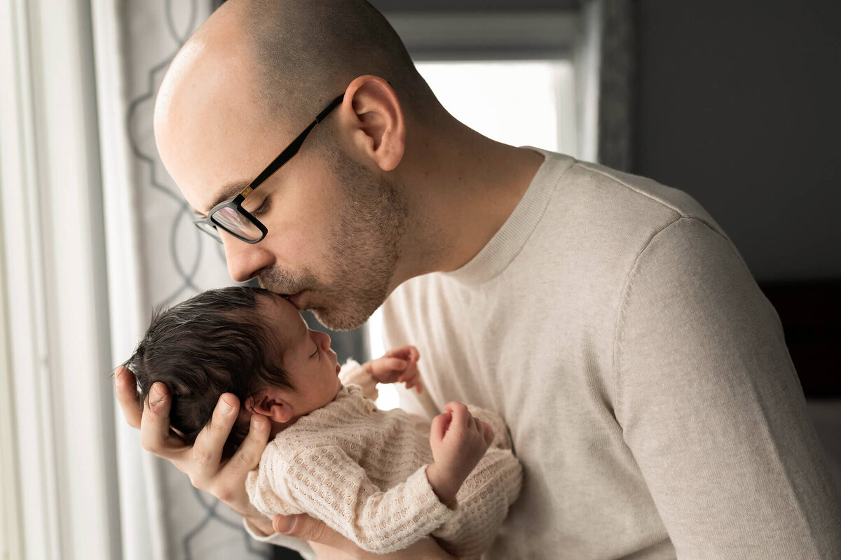 NJ baby photographer poses dad kissing his baby's head
