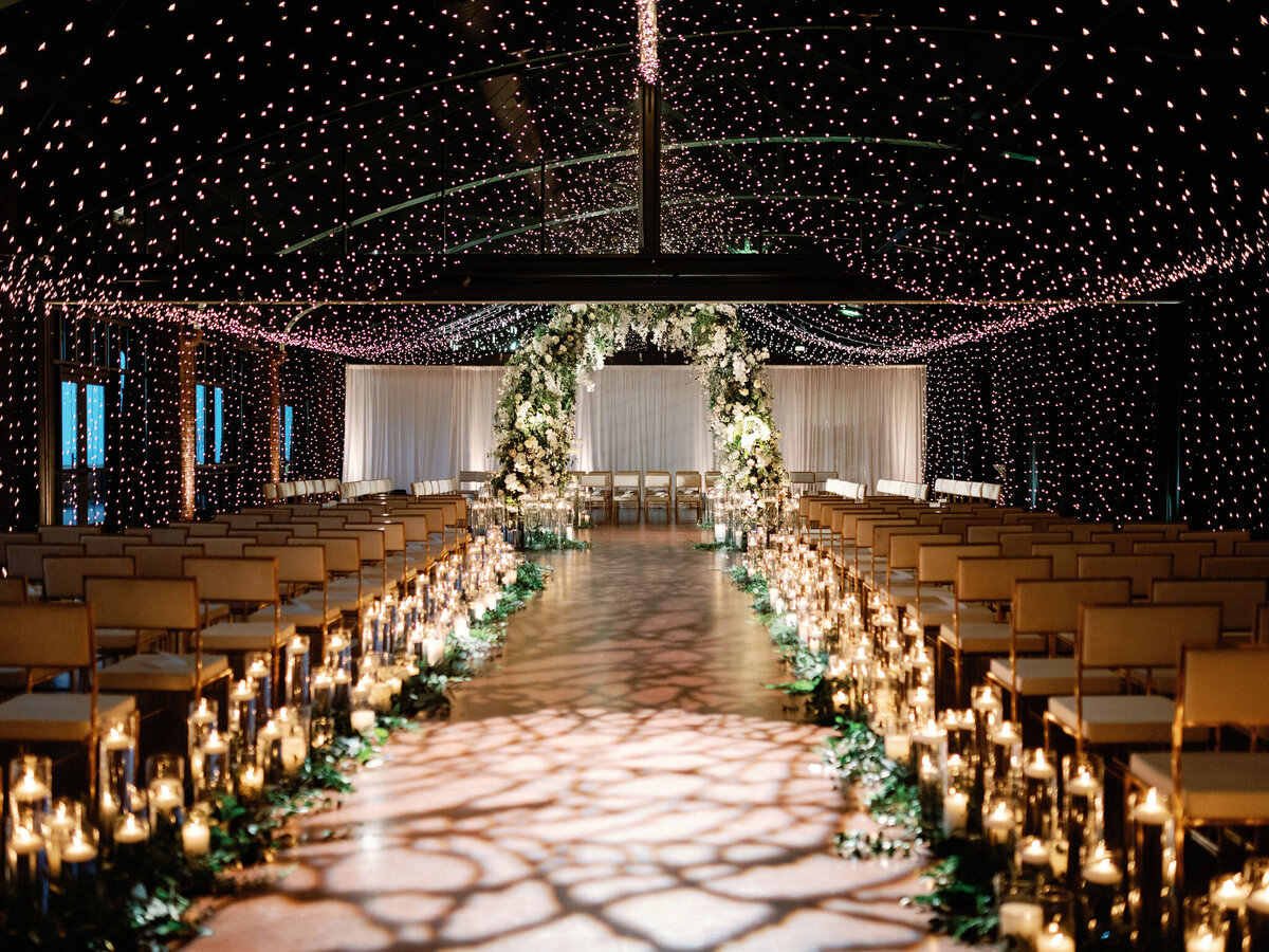 Rows of chairs lined with candles and flowers up to the wedding alter. 