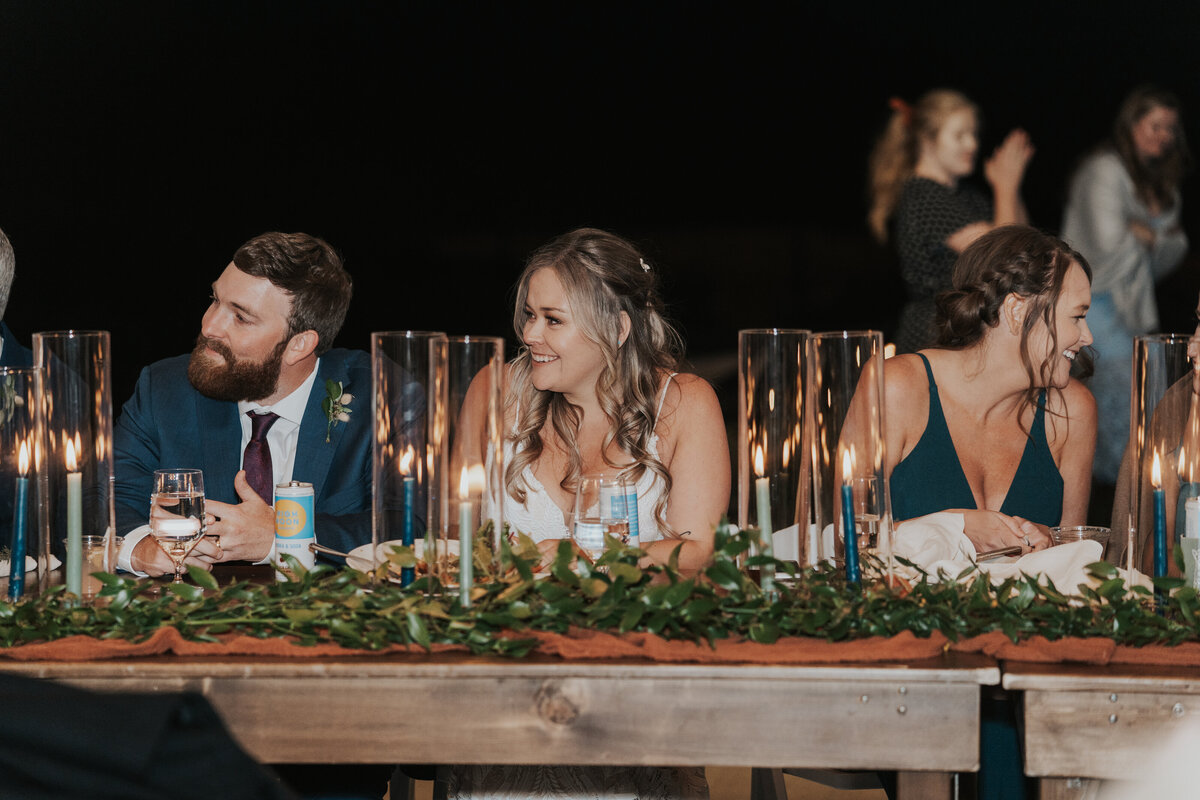 Bride and groom enjoy speeches during their wedding reception.