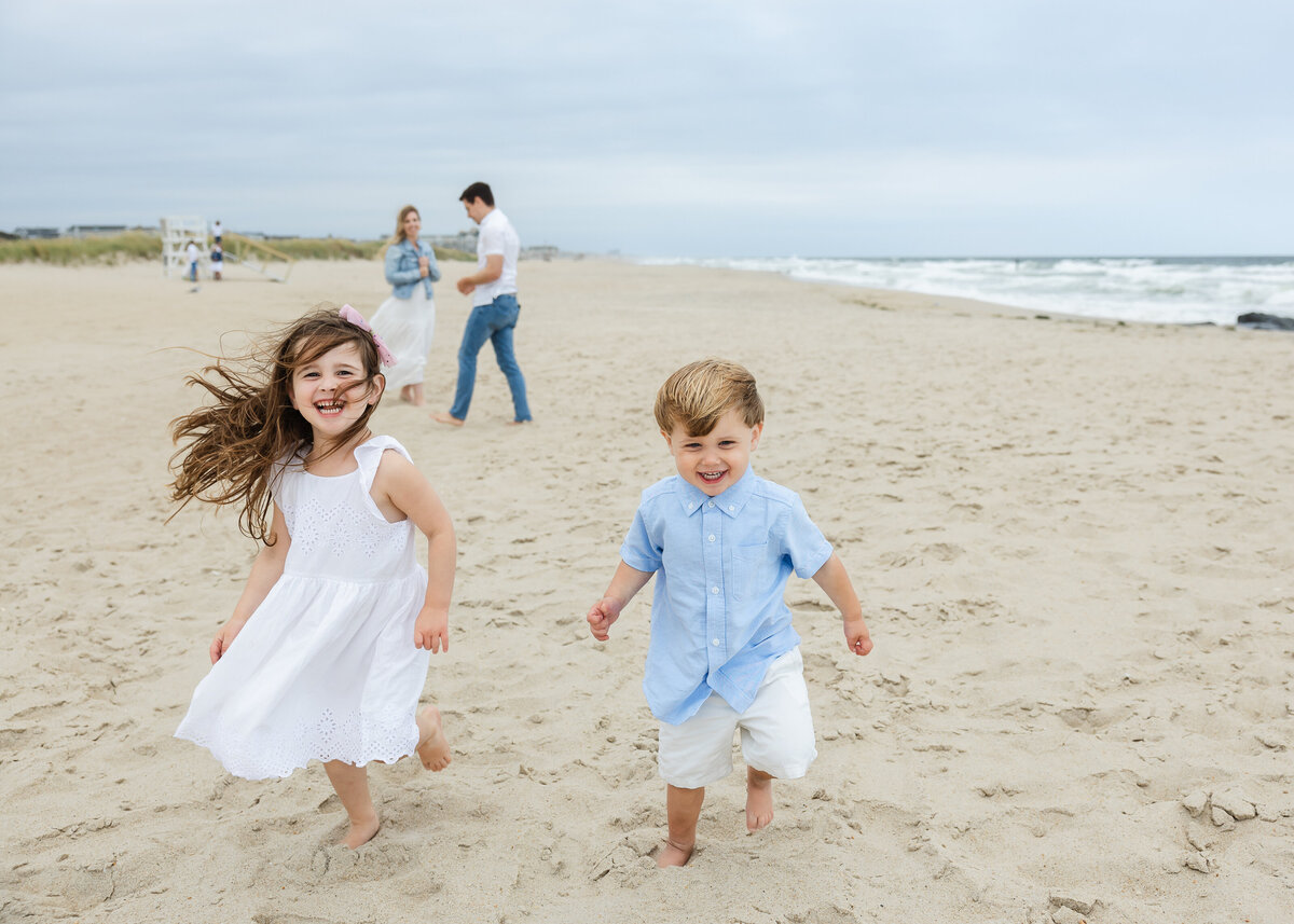 Family laughing and running on beach at the New Jersey shore.