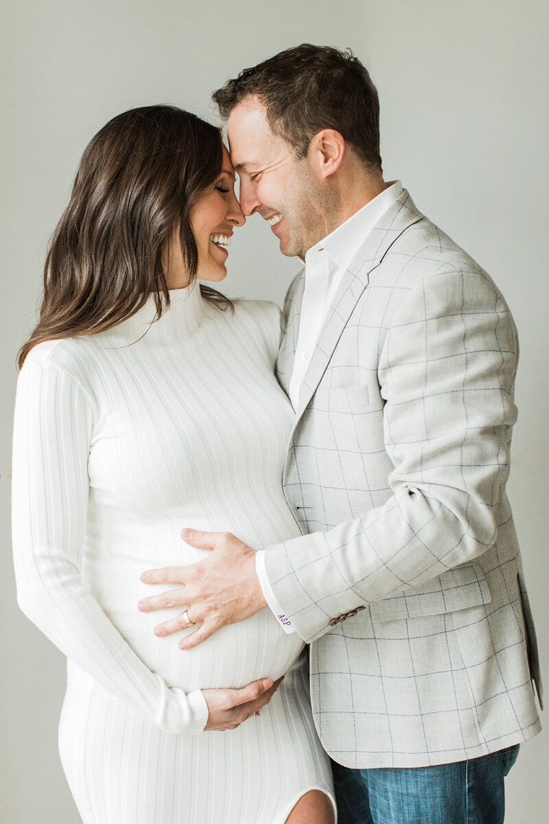 expecting parents in nashville husband wears a blazer and pregnant mom wears a form fitting dress