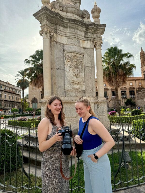 Fashion photographer and MUAH are looking at the back of a camera in Italy