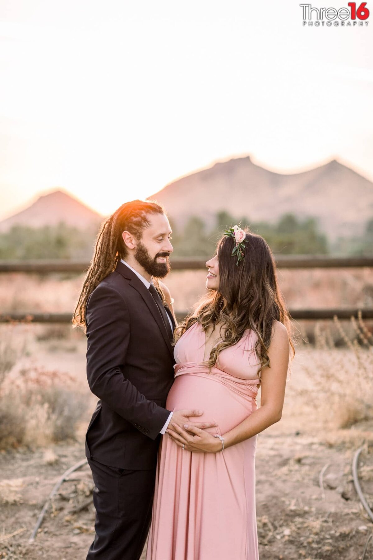 Dad to be places his hand on his Wife's stomach during maternity photo shoot