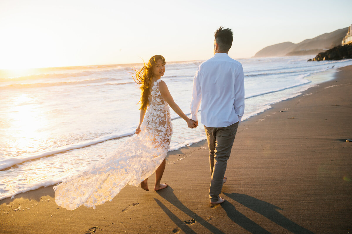 man and woman walk along the beach