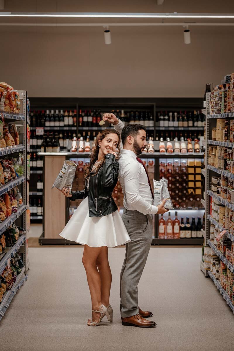 Séance photo de couple complice et décalée dans un magasin, posant avec des chips dans une ambiance légère et spontanée.
