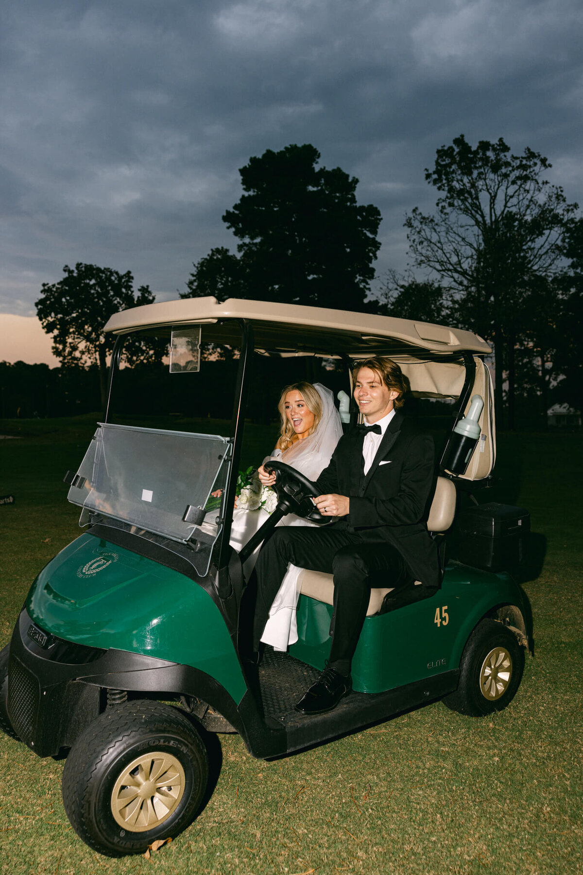 A wedding portrait photo of the bride and groom after their ceremony in a golf cart