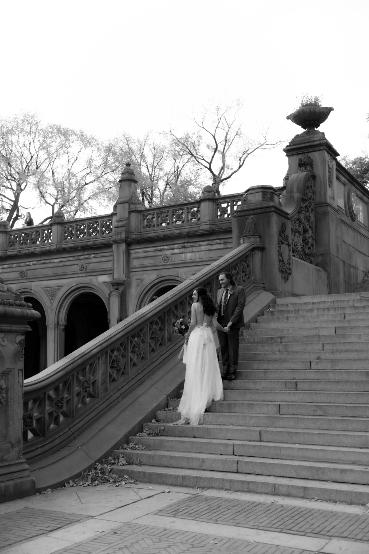 Black and white shot of the couple standing closely together in Central Park.