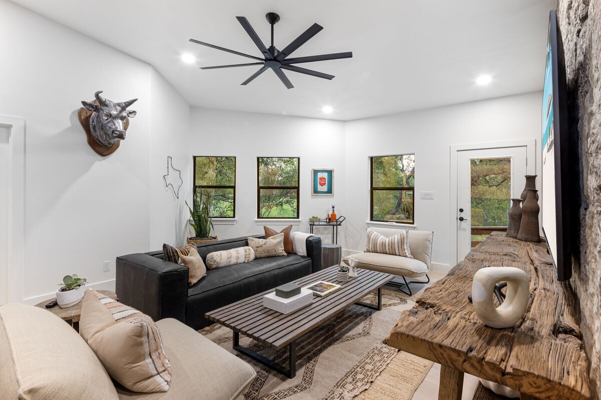 Black and white colour palette living room with black fan and bull horns on the wall