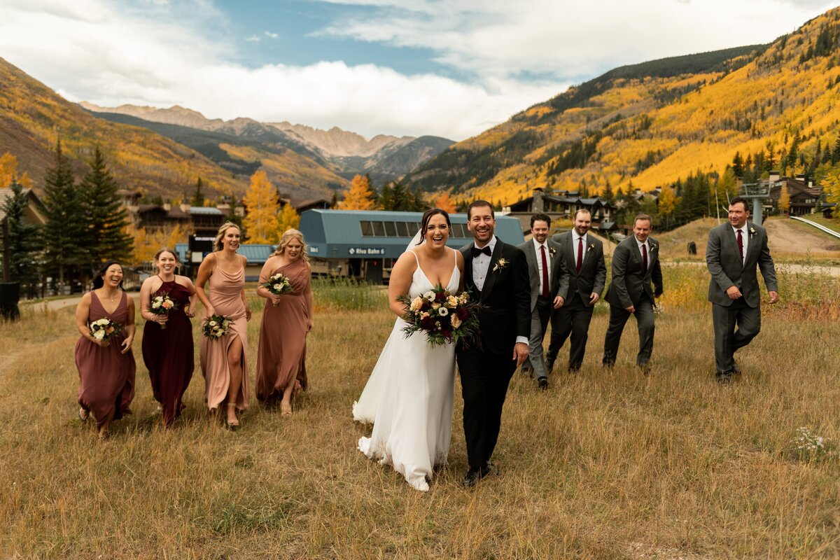 Bride and groom walk with their bridal party  in the Fall in Vail, Colorado.