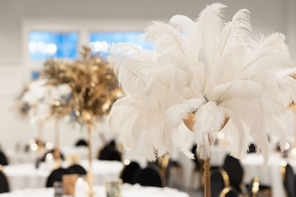 White feather centerpiece  and black velvet chairs for Great Gatsby Sweet 16