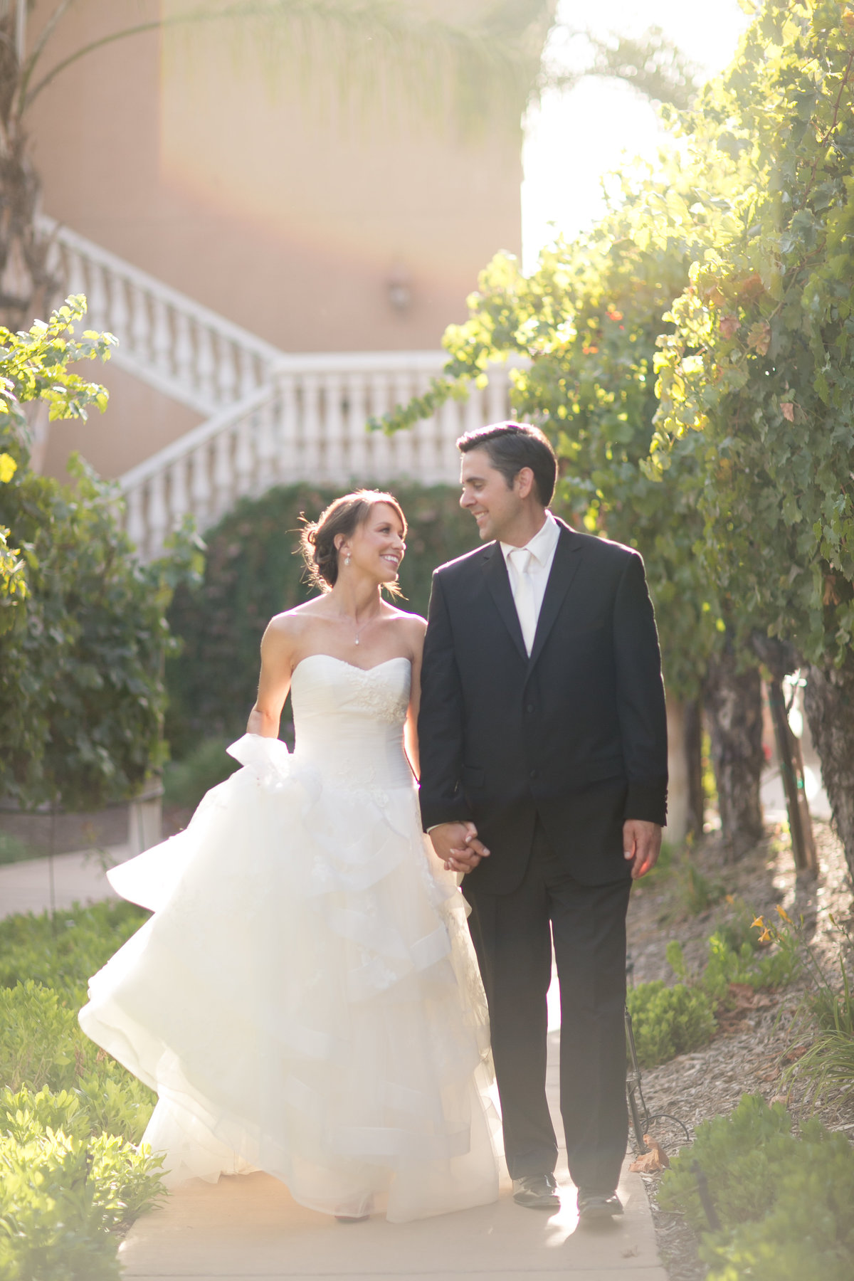 Bride and groom walking through a vineyard in Temecula California