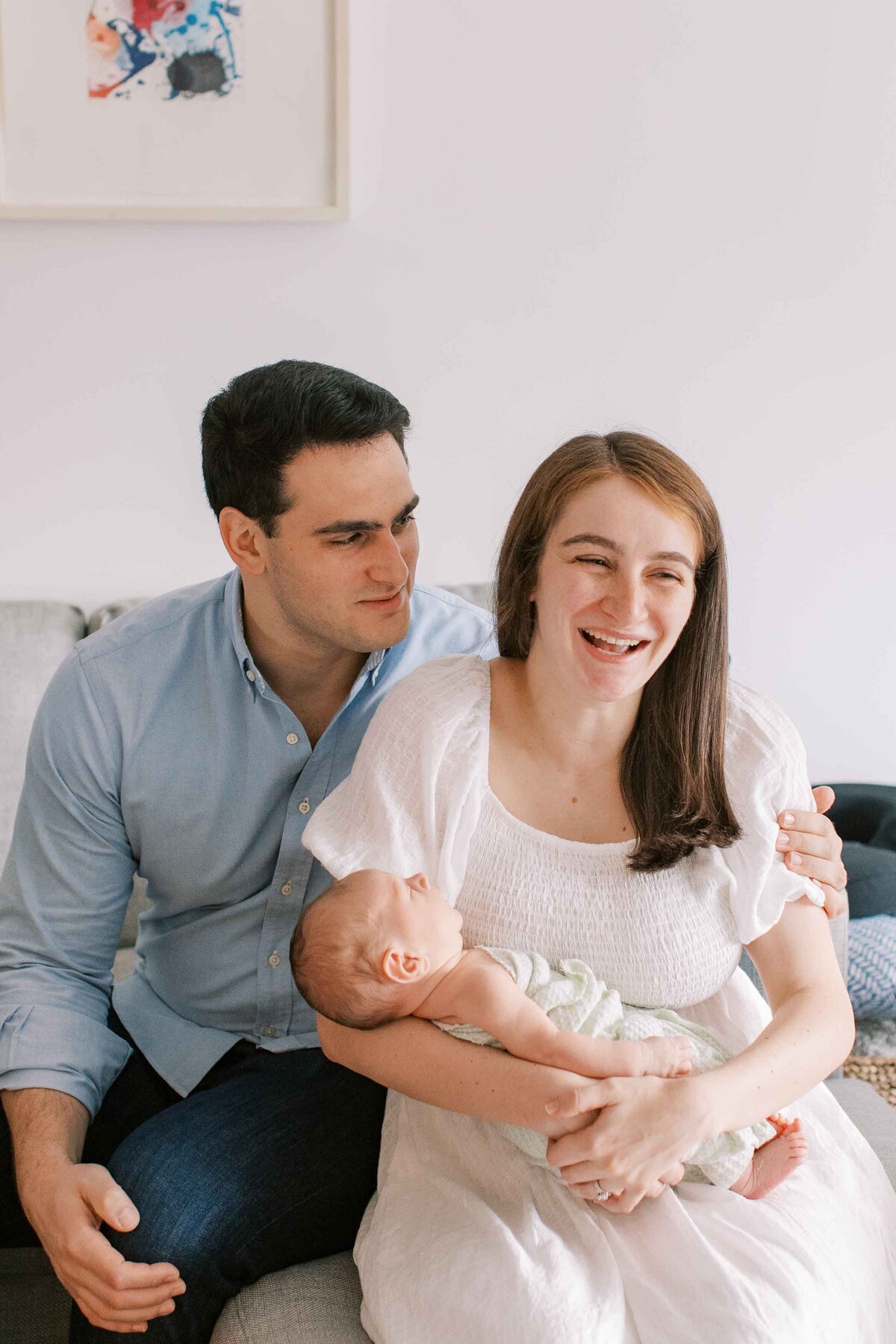 Parents laughing while holding their new baby boy