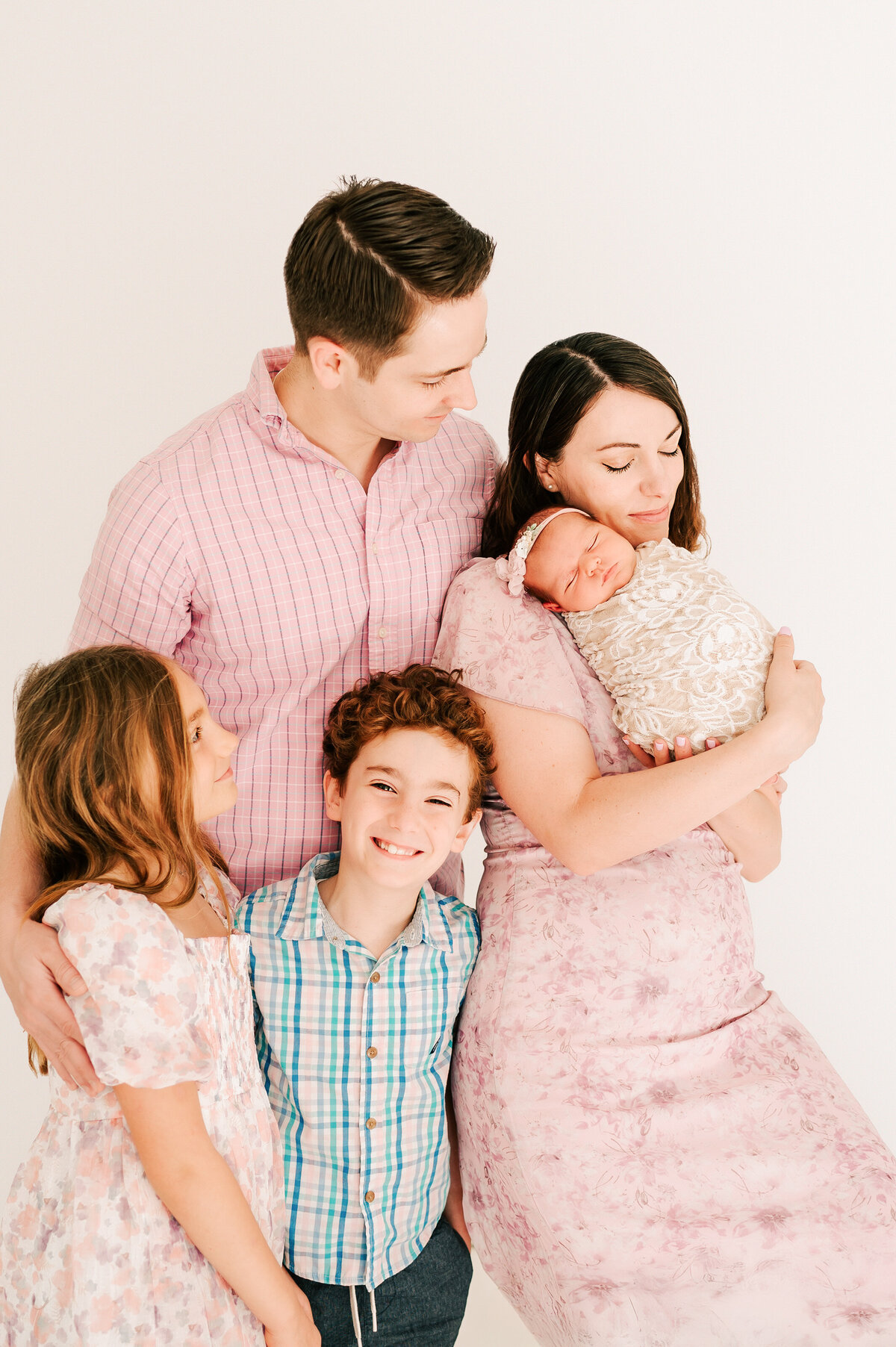 baby photographer in Springfield MO of family in photography studio cuddling newborn baby sister