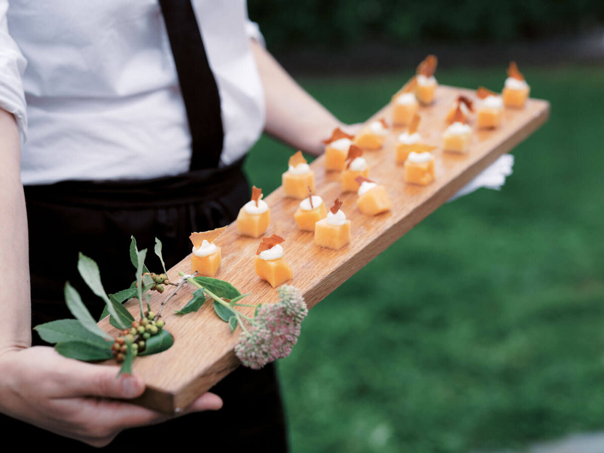 Sushi on a wood slab plate to be served at a wedding at The Lion Rock Farm, CT. Image by Jenny Fu Studio