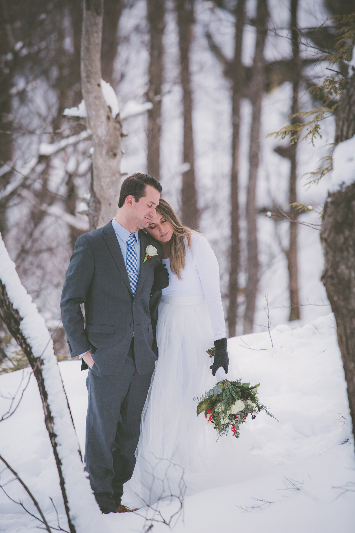 Couple leans on each other and closes eyes while enjoying their hiking elopement.