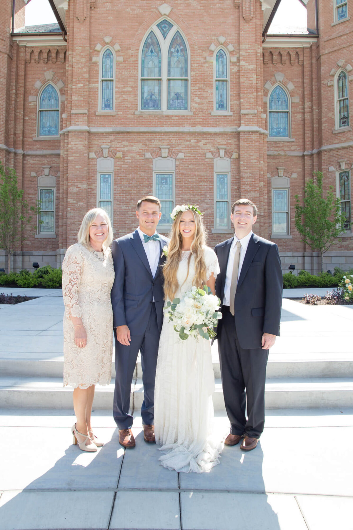 four adults posing at a wedding