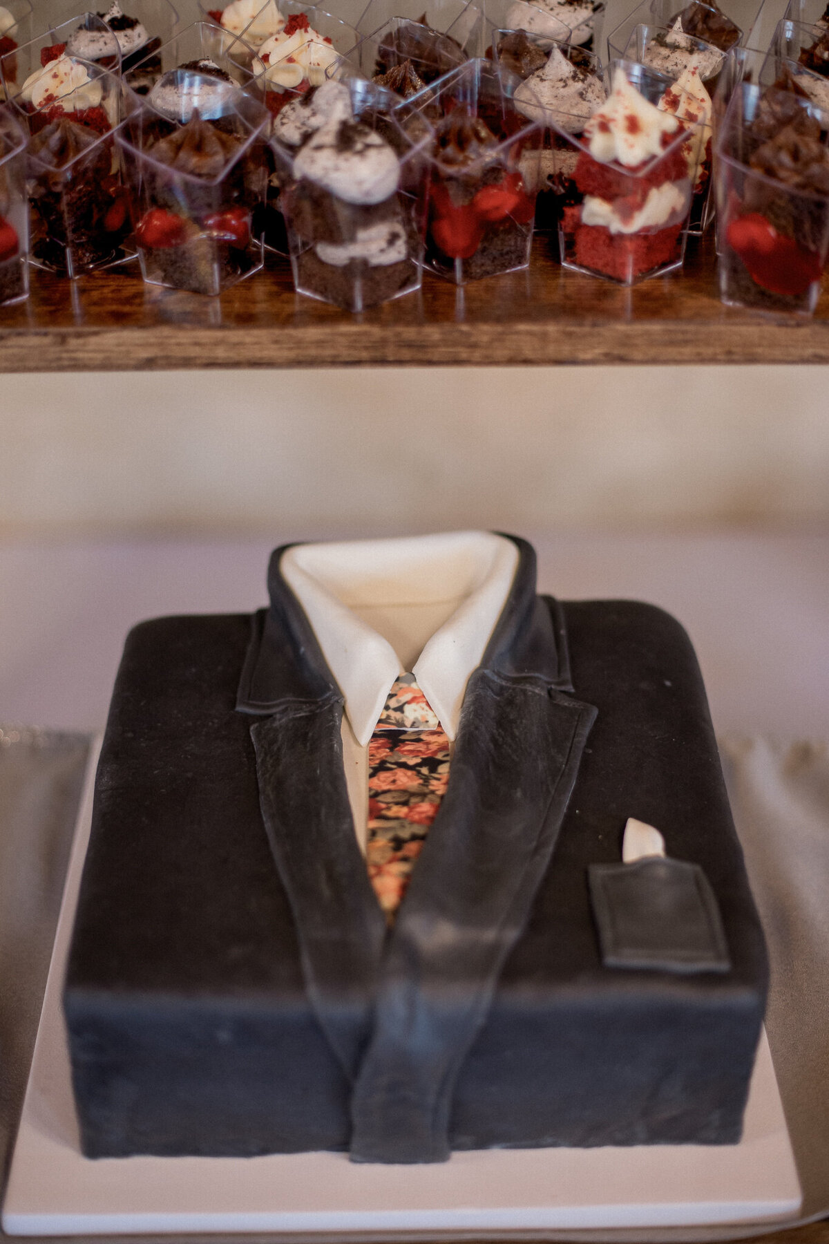 the grooms cake, shaped like a tuxedo and accented with a floral tie