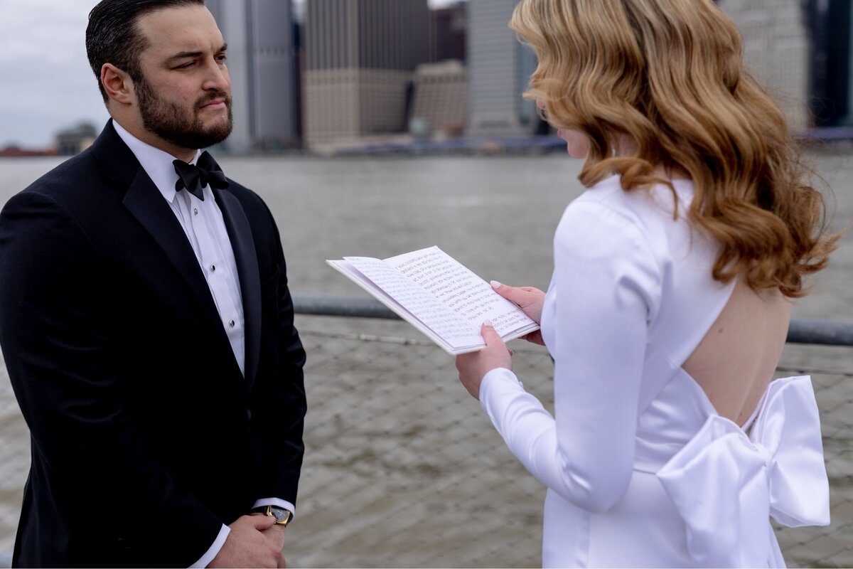 Bride reads her vows to the Groom while saying I Do in NYC in front of the river.