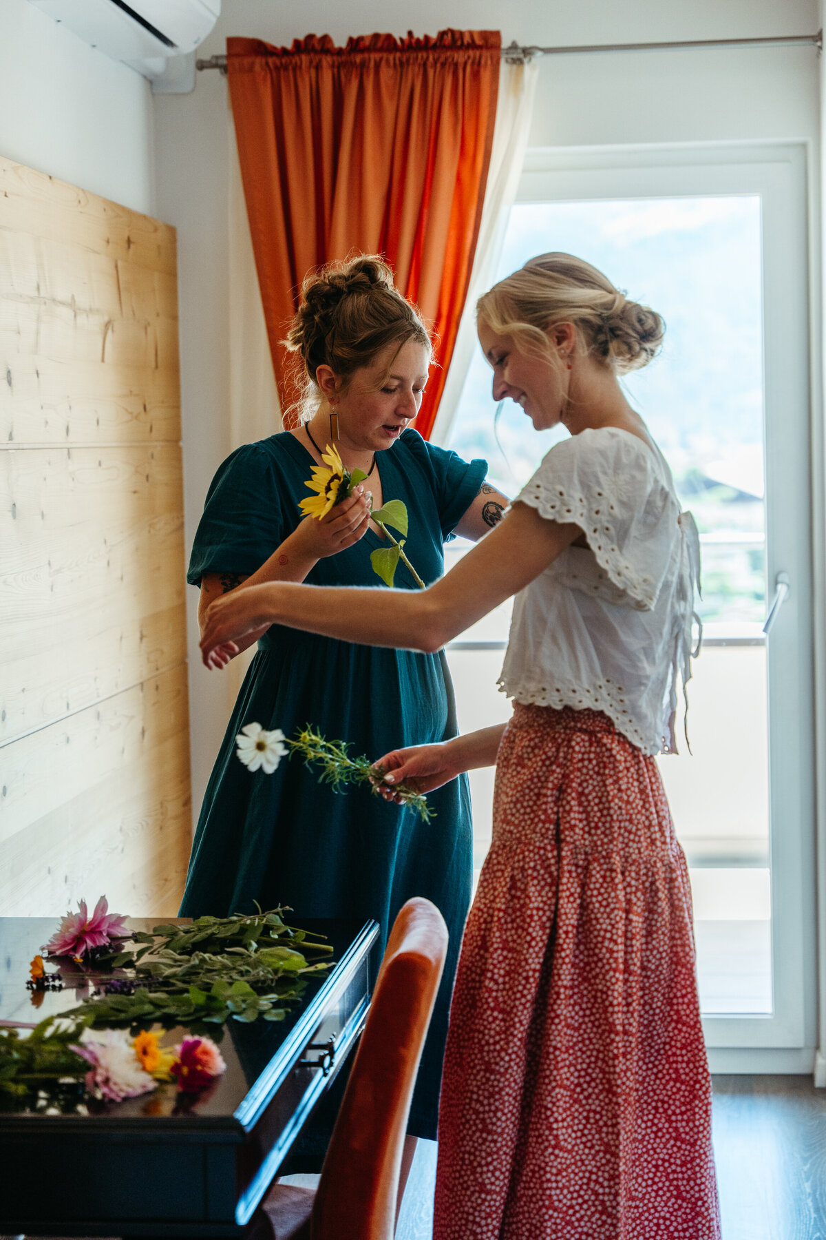 Women arranging flowers together in hotel lounge