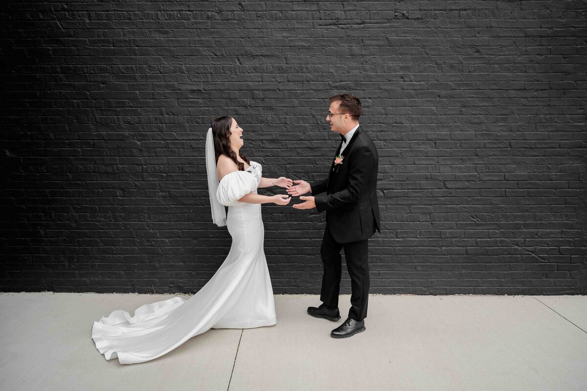 Bride and groom first look in front of black wall at Sarabande 
