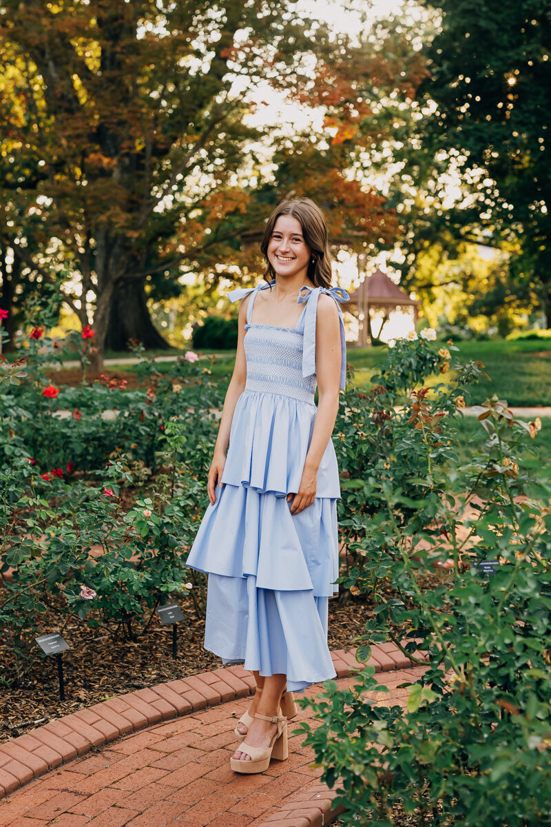 Senior standing in a rose garden outside Belmont Mansion during a portrait session with Lydia McRae Photography