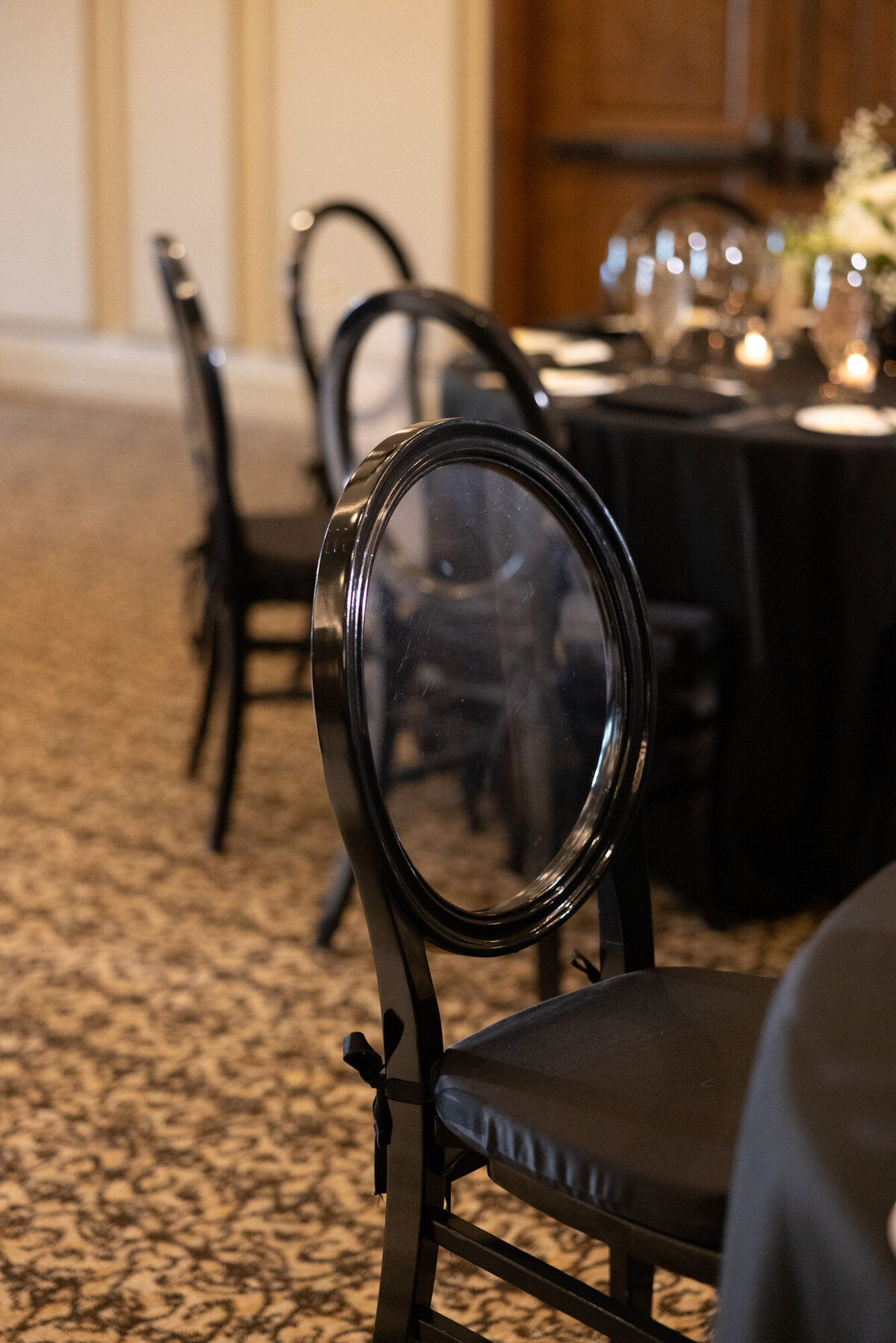 Black dining chairs at wedding reception