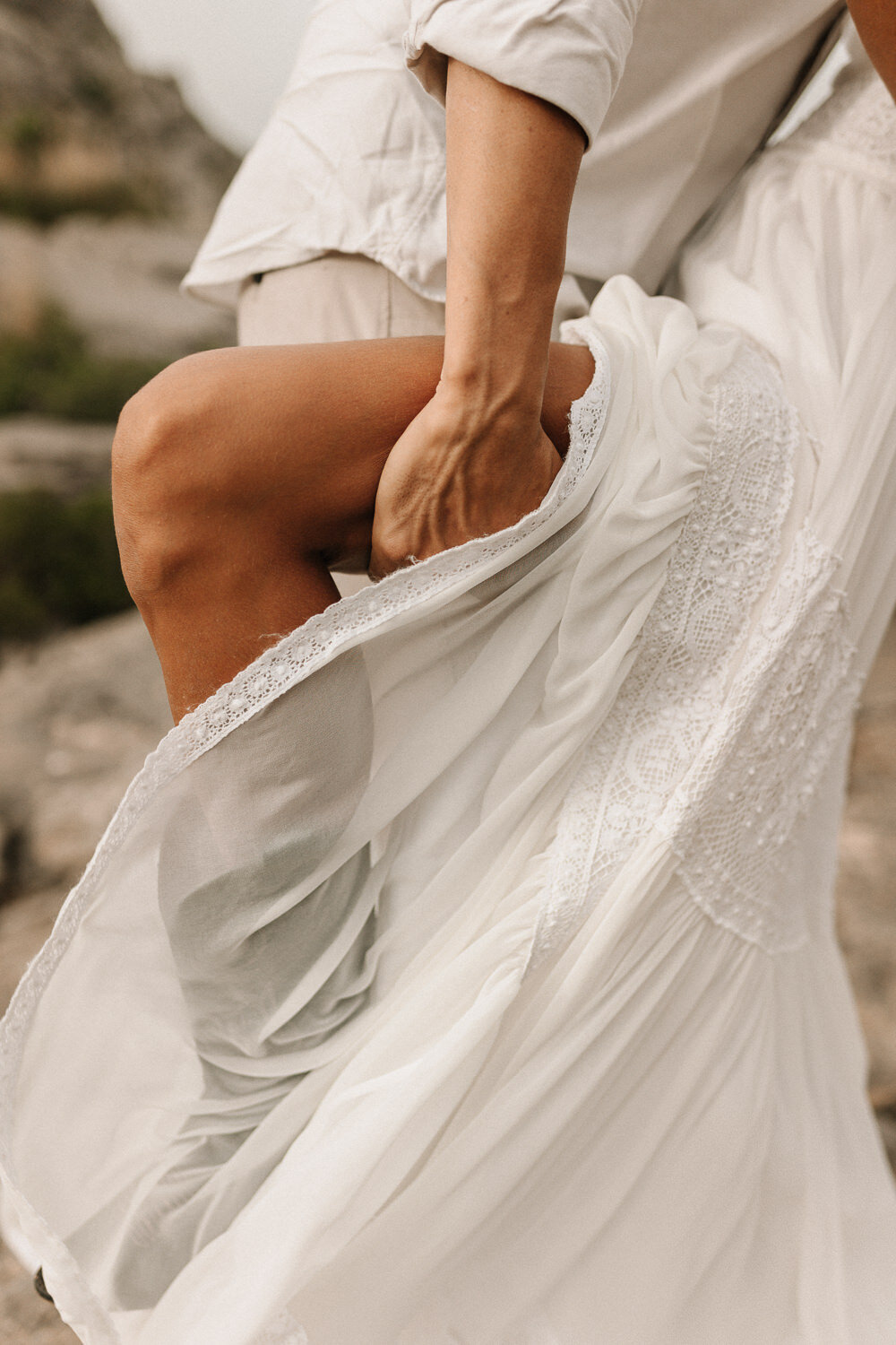 Bein einer Braut mit Kleid im Wind