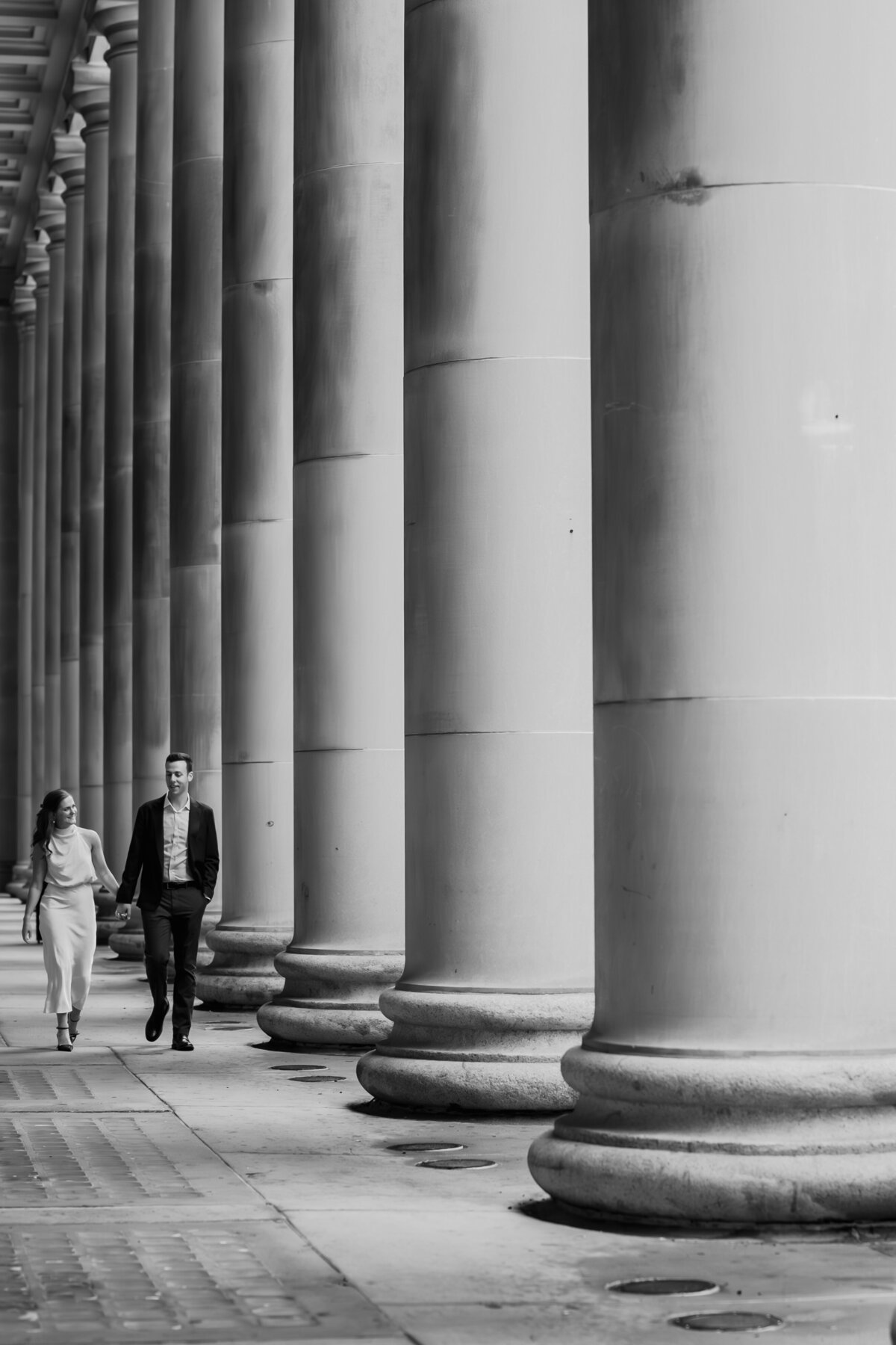 A couple walk next to the Pillars at Chicago Union Station.