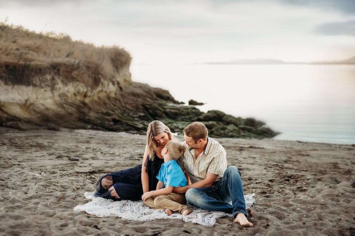 family sitting on a beach of the San Francisco bay 