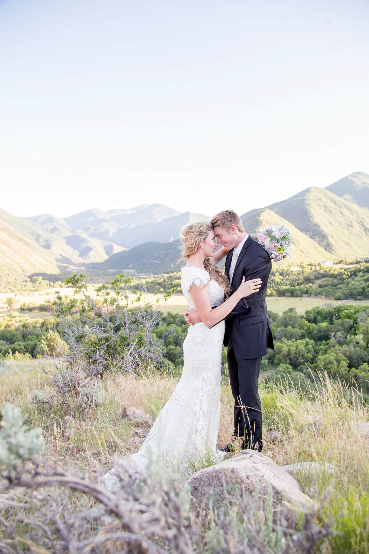 Stunning mountain view of wedding couple with foreheads together during their bridal session with las vegas wedding photographer Jessica Bowles