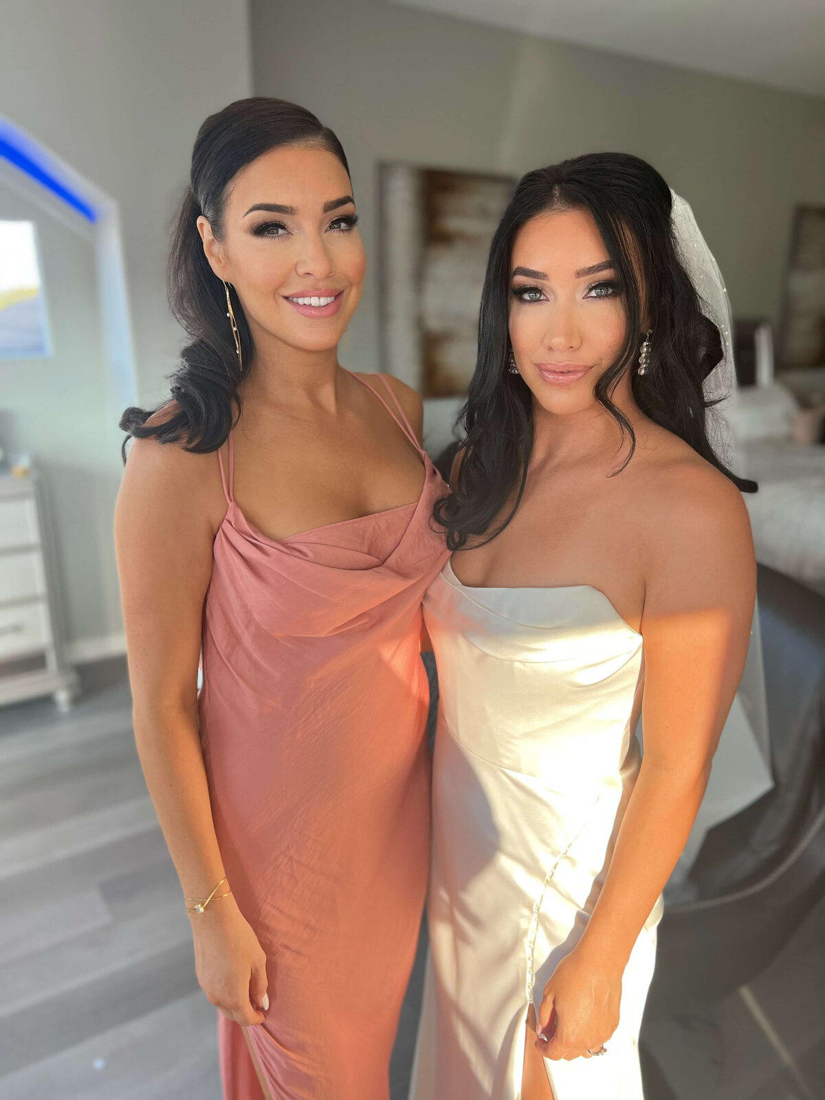 A stunning bride and her bridesmaid showcase flawless soft glam makeup and voluminous wedding hairstyles. Both looks were styled by Mistique Makeup, a top-rated wedding hair and makeup team in San Antonio and Austin. Ideal for modern brides seeking timeless elegance with a touch of glam. Perfect inspiration for bridal party hair and makeup styling.