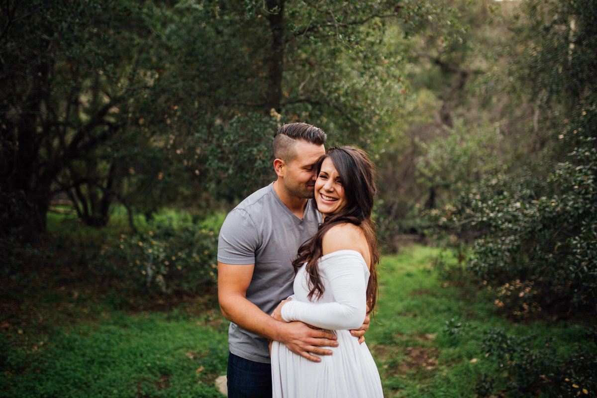 Dad to be whispers in his Wife's ear during a maternity session leaving her a big smile
