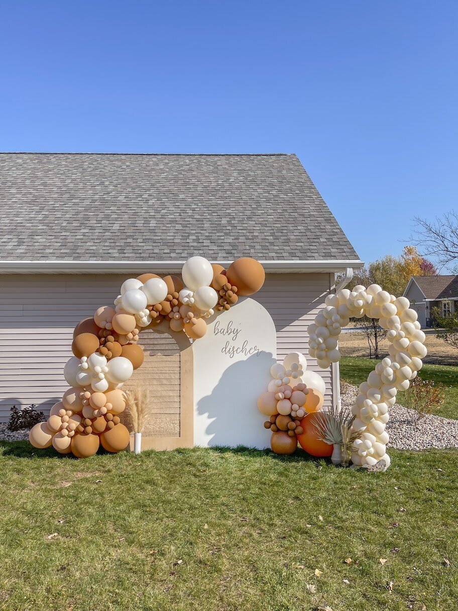 Tan and white balloons on wooden backdrops with a giant balloon question mark