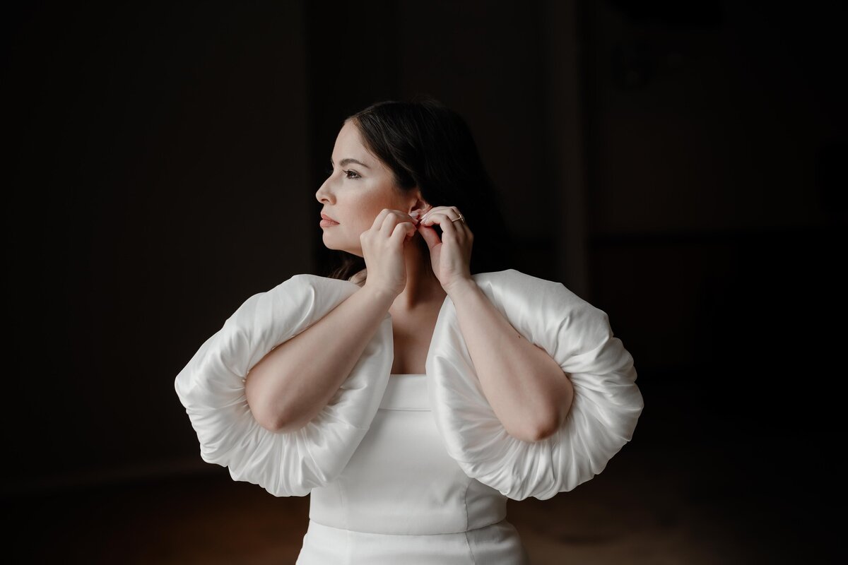 HIgh fasion bride puts on jewelry at Sarabande  