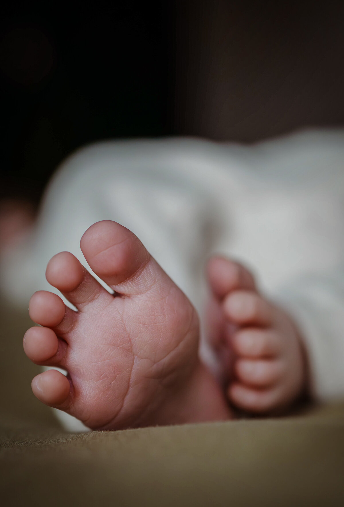 close up van de voetjes van de baby met een voetje op de voorgrond en achtergrond wazig