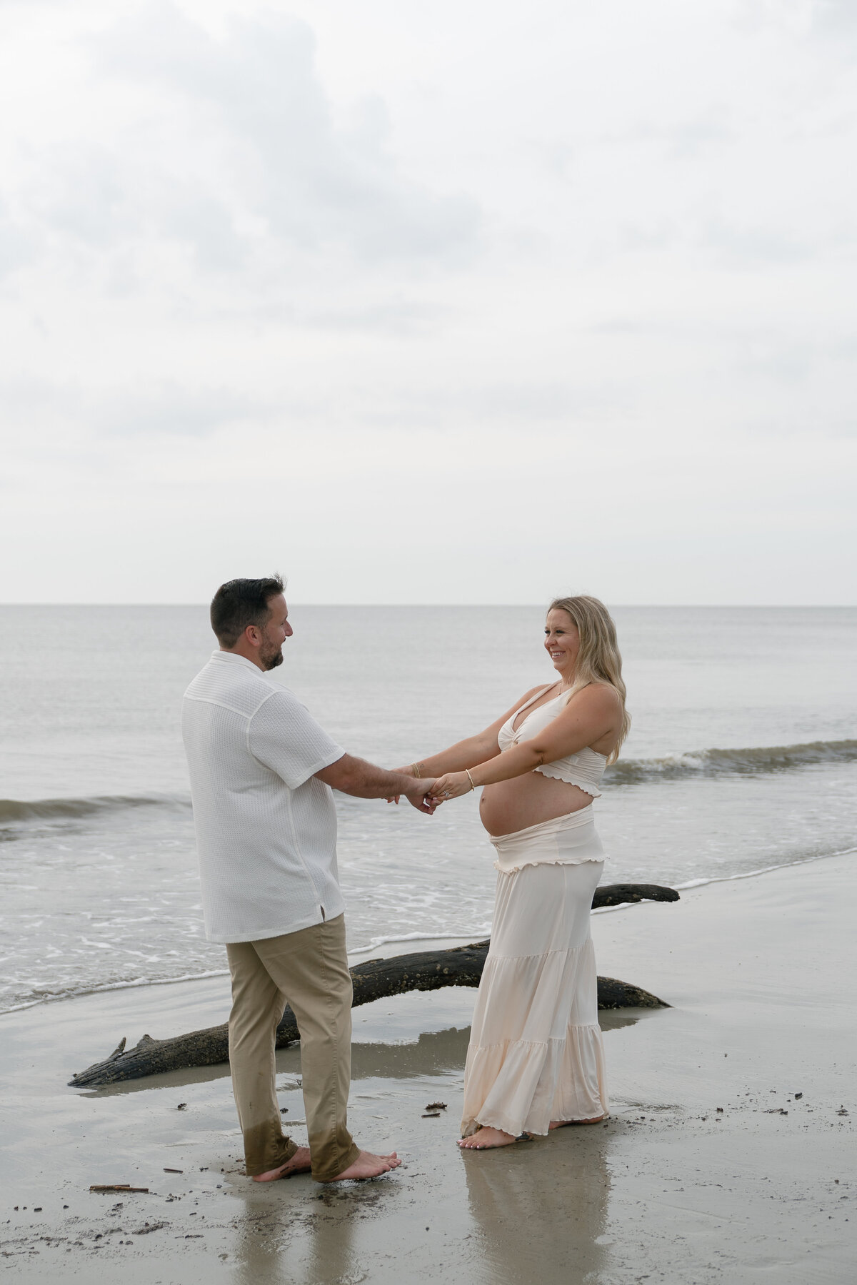 Maternity couple holding hands on beach taken by florida engagement photographer Shelby Ann Photos