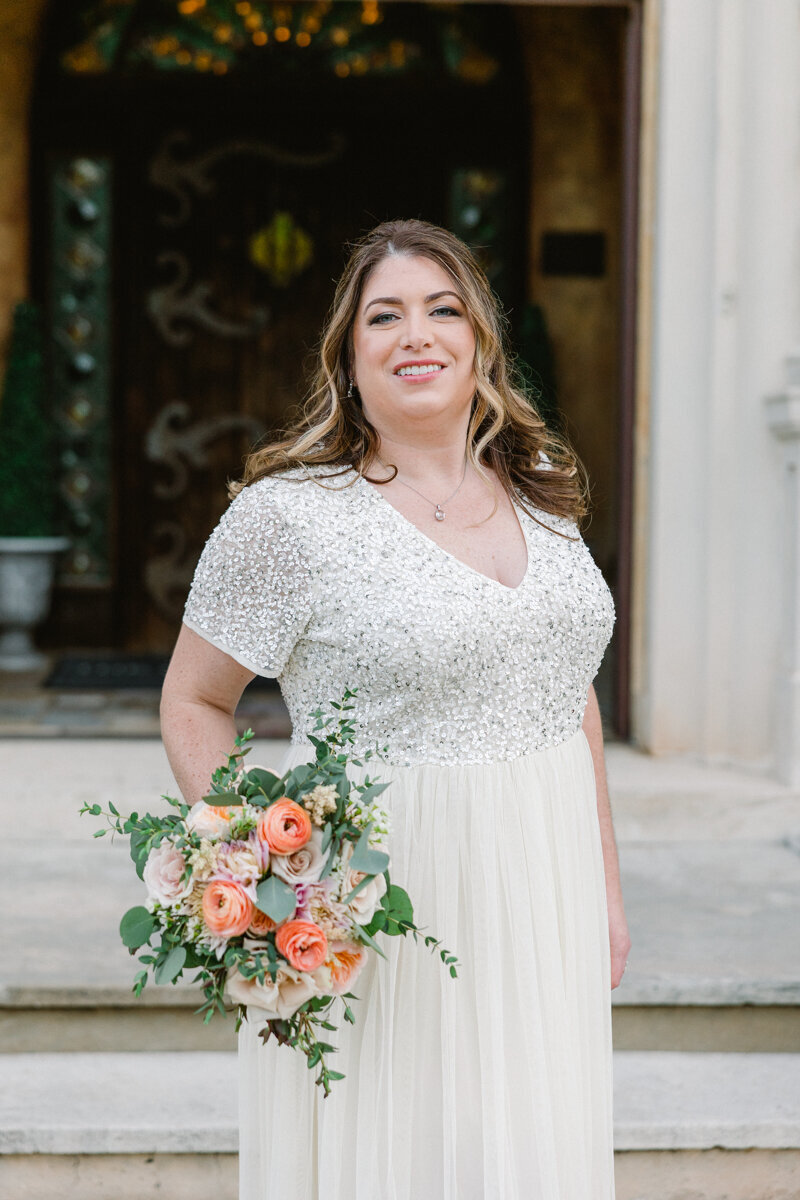 bride smiling holding flowers at howey mansion wedding